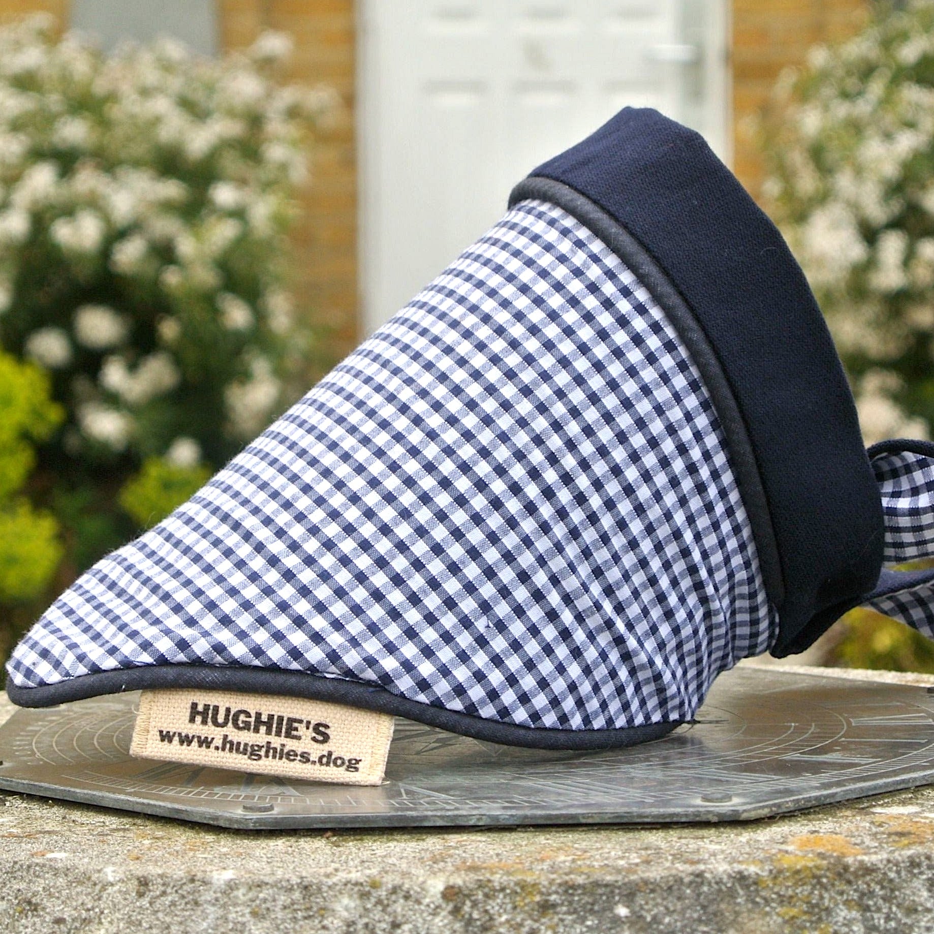 Midnight Blue Gingham Tie-on Dog Bandana (reversible) photographed placed on a weather dial in a country garden