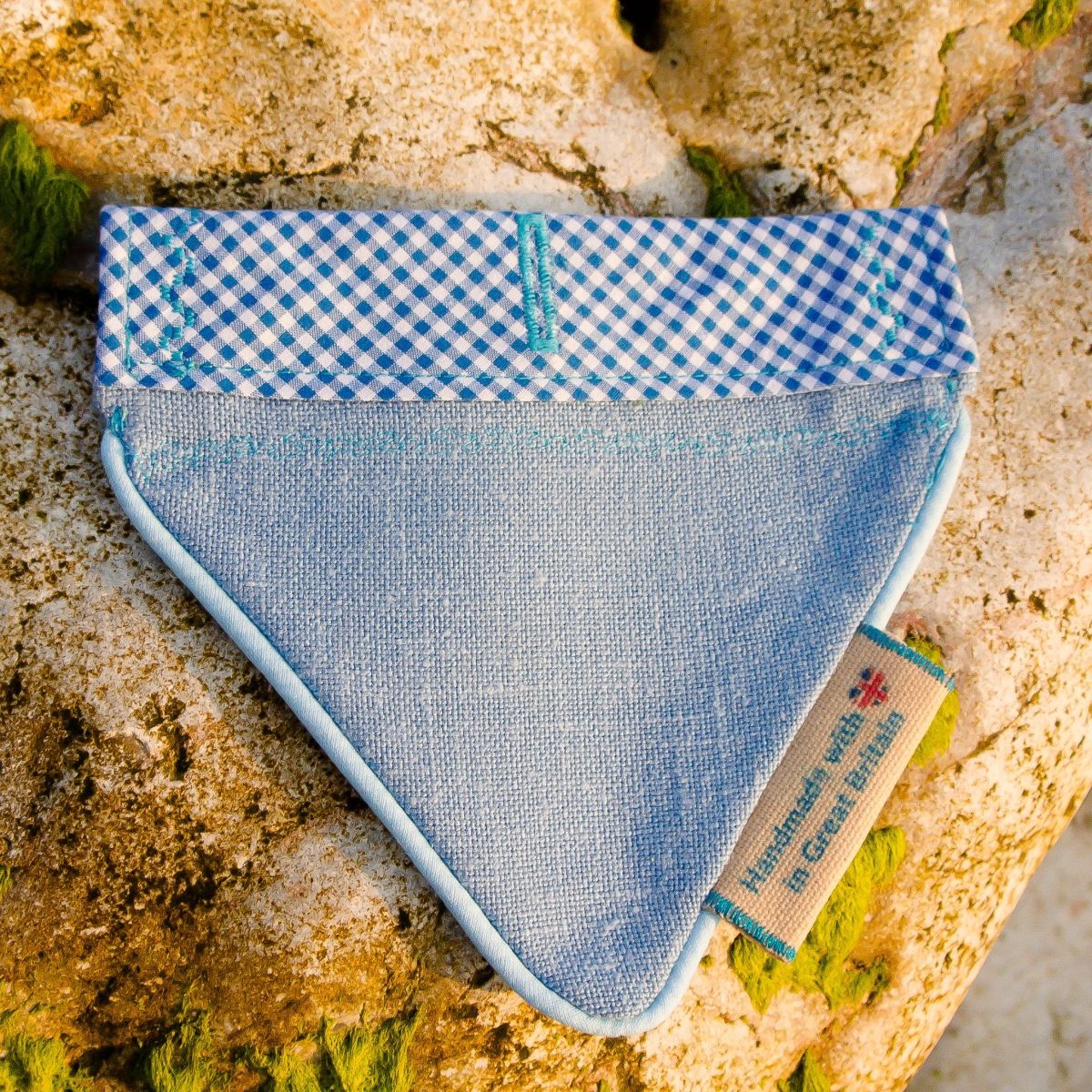 A luxury over collar dog bandana on a rock.