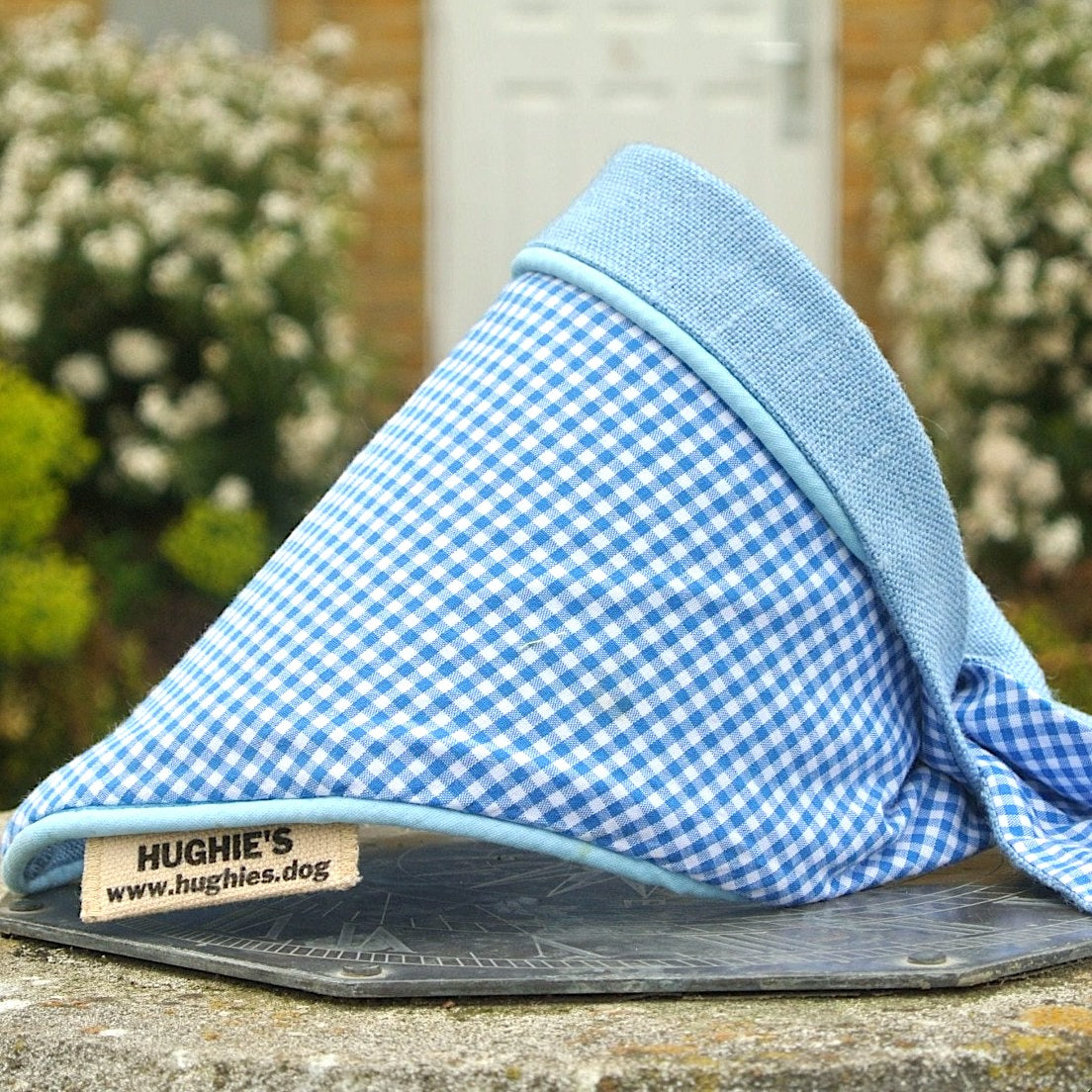 sky blue Gingham Tie-on Dog Bandana (reversible) photographed placed on a weather dial in a country garden