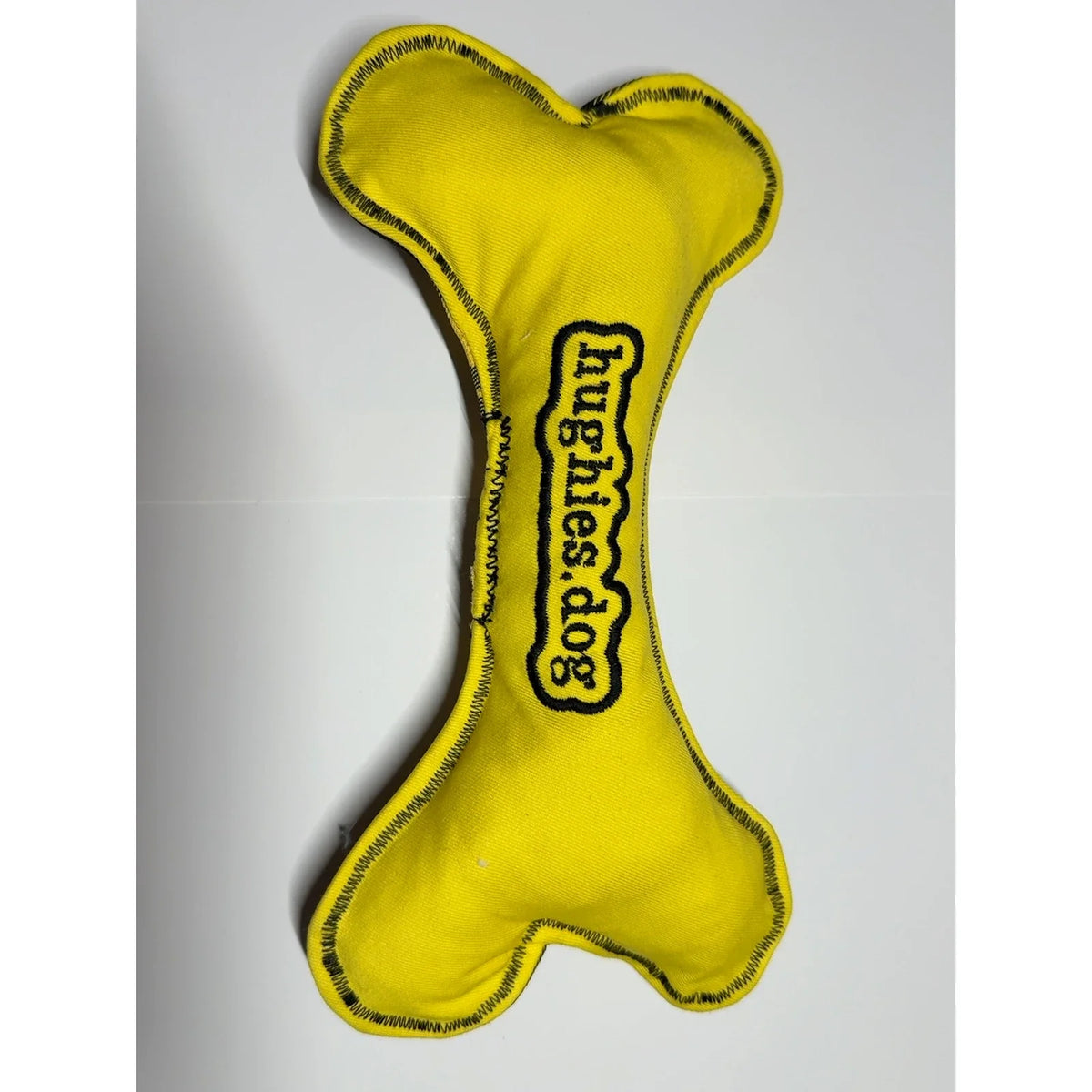Yellow reverse of autumn check soft dog bone toy with embroidered Hughies dog logo
