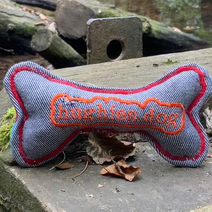Rear of
Bone-shaped dog toy with 'hughies dog' embroidery on a natural background