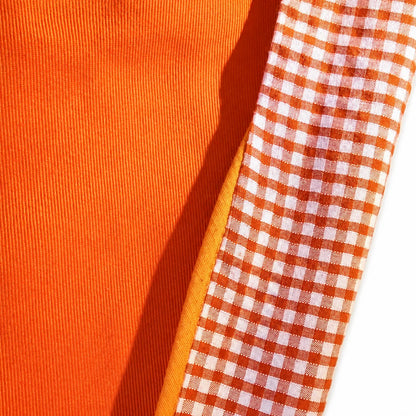 Close-up of orange cotton and orange gingham fabric used for the reversible dog bandana