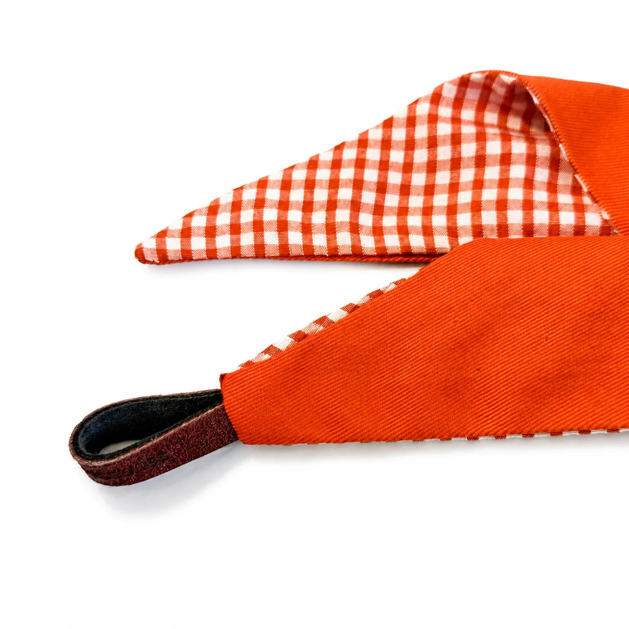 Detail of the reversible orange gingham tie-on dog bandana and helper loop