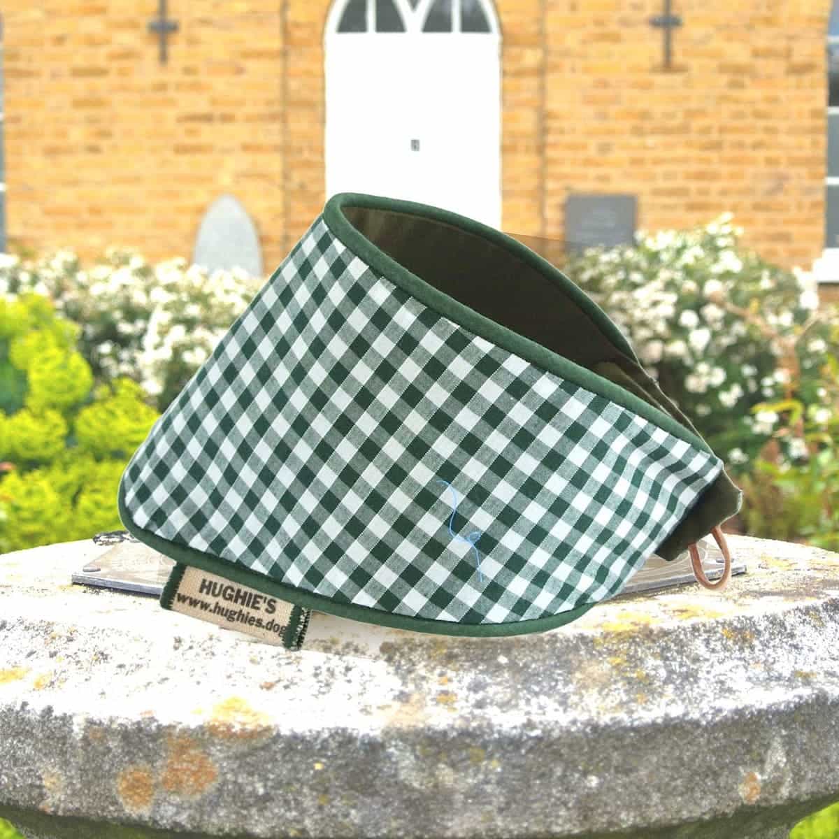 British Racing Green Gingham Snap-on Dog Bandana (reversible) photographed placed on a weather dial in a country garden 
