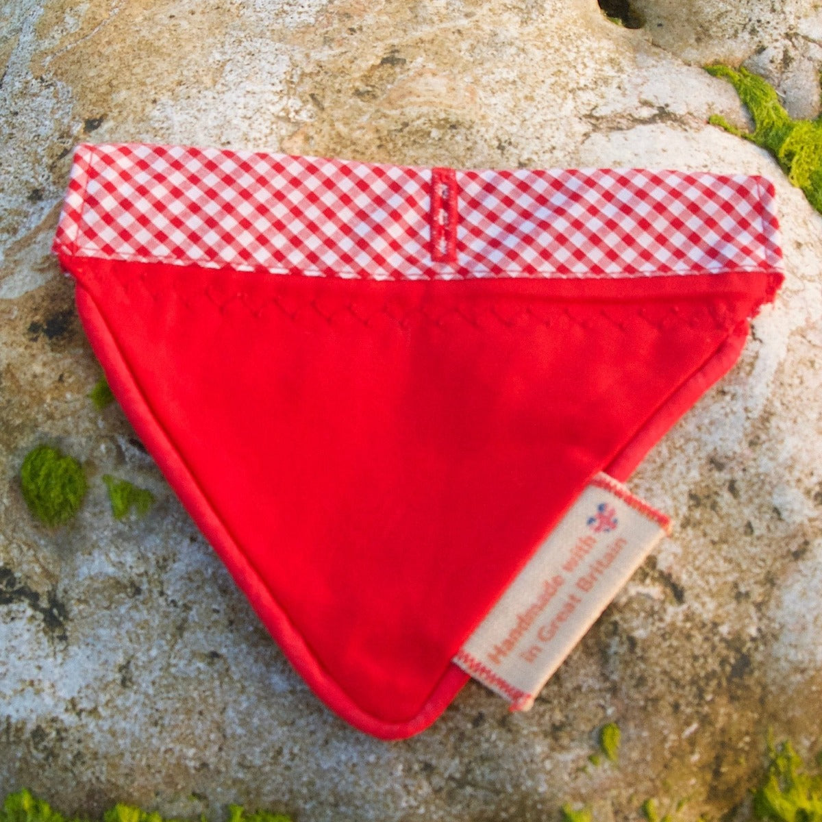 Red Gingham Over-collar Dog Bandana laying flat showing the reverse side on a rock 