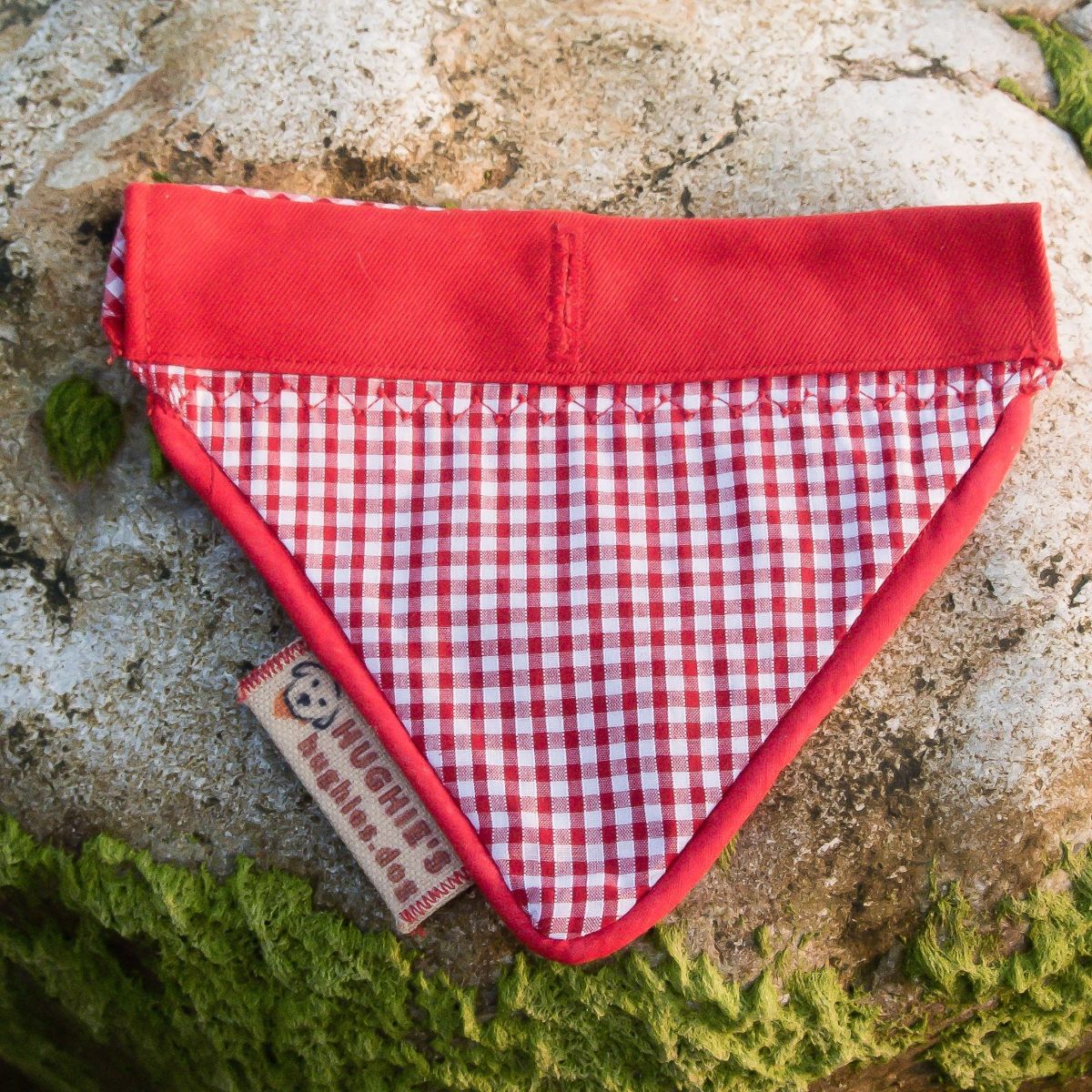 Red Gingham Over-collar Dog Bandana laying flat on a rock 
