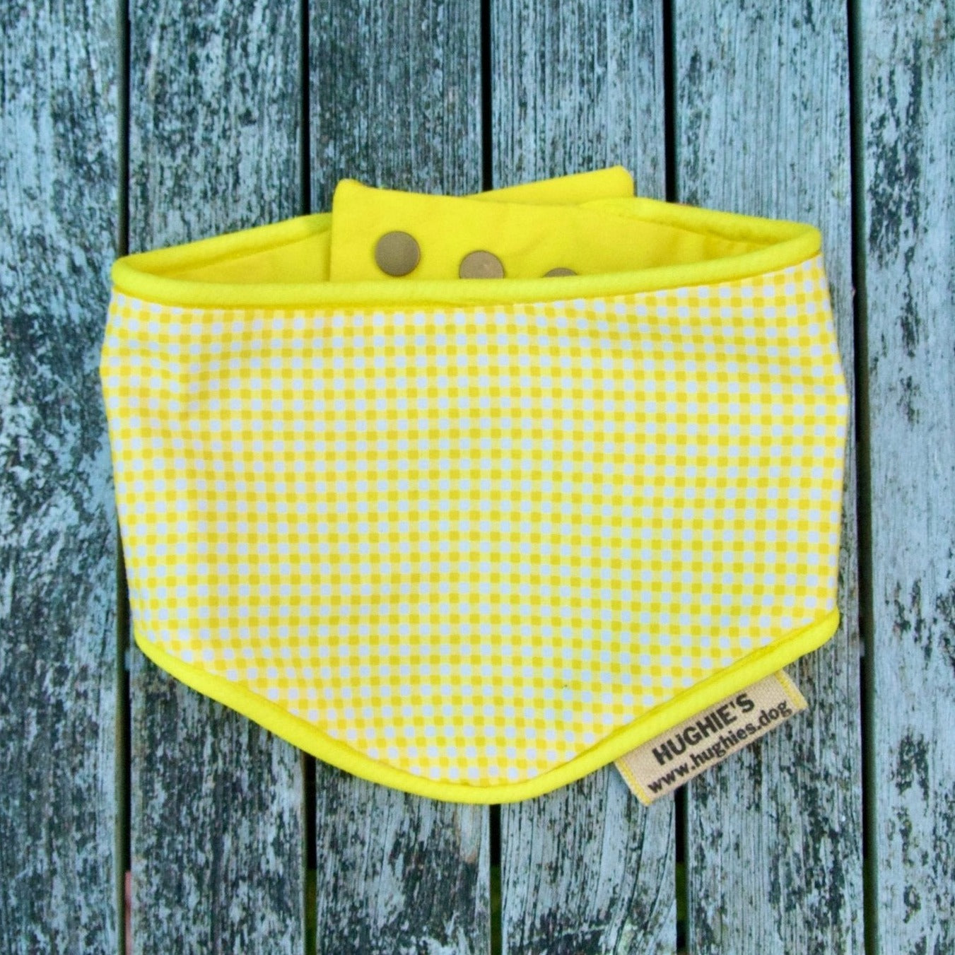 yellow and white gingham bandana on a wooden surface.